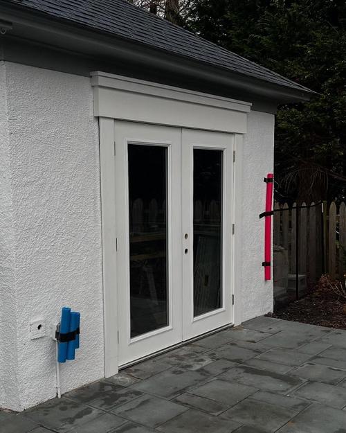 Finished French doors with a crowned trim header and white casing