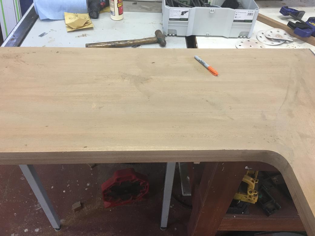Sanded L-shaped wooden desktop on a workbench in the shop, before finishing