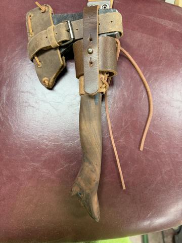 Hand-carved wooden hatchet handle with a leather blade sheath