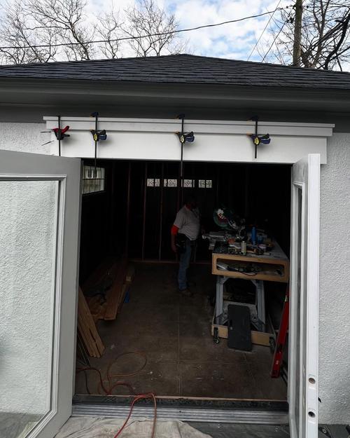 New French doors standing open, with fresh header trim held by clamps