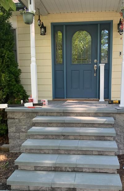 Before: a front stoop with no railings, its steps leading up to a blue door